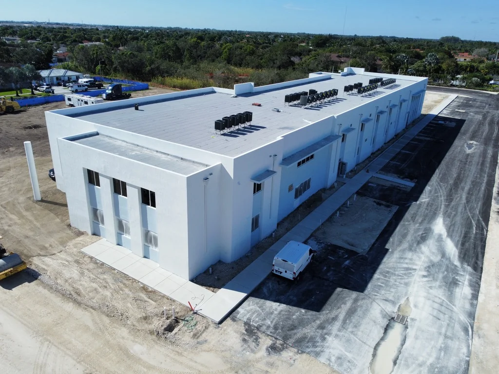 SW 216th Street campus in November 2023, with a white exterior and paving work underway